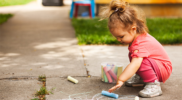 Activities like drawing on the sidewalk with chalk let young children express their emotions through play, helping their pediatric development.