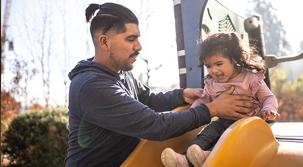 El tiempo de calidad entre un papá y su hija pequeña en un parque infantil es una de las formas en las que él marca una diferencia en la vida de su hija.  