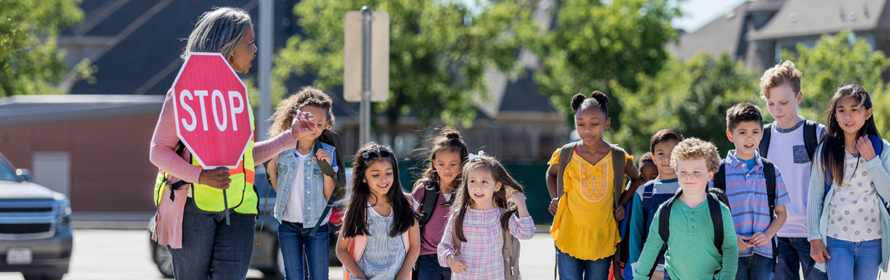 Crossing guards help school kids safely cross the street.