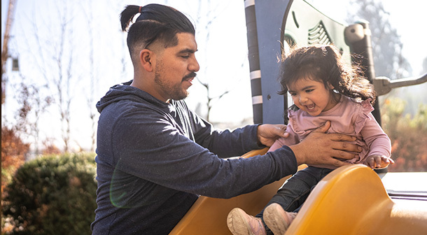 Quality time between a dad and young daughter at a playground is one way he make a difference in his kid's life. 
