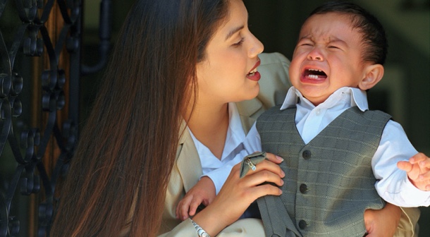 mother comforts toddler boy throwing tantrum